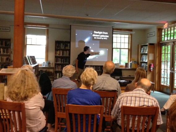 Community members attend a talk titled "Why is it dark at night?" at the Putney Public Library with Tom Geballe